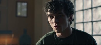 Movie still from “Black Mirror: Bandersnatch” (2018), directed by David Slade – A young man is looking into the distance; Close Up shot, Over the shoulder angle