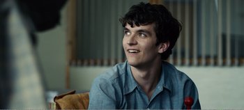 Movie still from “Black Mirror: Bandersnatch” (2018), directed by David Slade – A man sitting on top of a couch looking up; Close Up shot, Over the shoulder angle