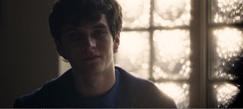 Movie still from “Black Mirror: Bandersnatch” (2018), directed by David Slade – A young man is standing in front of a window; Close Up shot, Over the shoulder angle