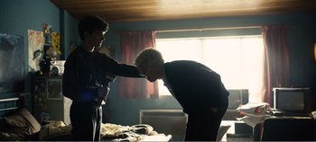 Movie still from “Black Mirror: Bandersnatch” (2018), directed by David Slade – Two people in a room touching each other's hair; Medium shot, Over the shoulder angle