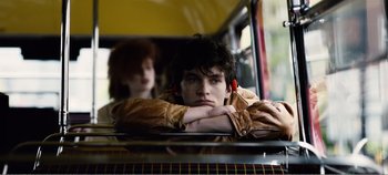 Movie still from “Black Mirror: Bandersnatch” (2018), directed by David Slade – A man sitting in a bus with a woman standing behind him; Close Up shot, Low angle