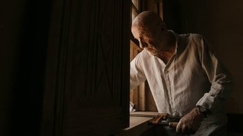 Movie still from “Better Call Saul” (2015), created by Vince Gilligan – An older man is working on a piece of wood; Medium shot, Low angle