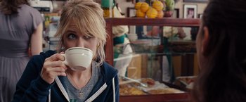 Movie still from “Bridesmaids” (2011), directed by Paul Feig – A woman drinking a cup of coffee in a kitchen; Close Up shot, Over the shoulder angle