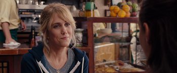 Movie still from “Bridesmaids” (2011), directed by Paul Feig – A woman sitting in front of a display case in a store; Close Up shot, Over the shoulder angle