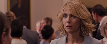 Movie still from “Bridesmaids” (2011), directed by Paul Feig – A person wearing a suit; Close Up shot, Over the shoulder angle