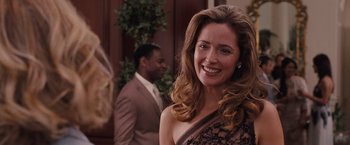 Movie still from “Bridesmaids” (2011), directed by Paul Feig – A beautiful woman in a brown dress smiling; Close Up shot, Over the shoulder angle