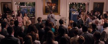 Movie still from “Bridesmaids” (2011), directed by Paul Feig – A man speaking to a crowd of people; Wide shot, Over the shoulder angle