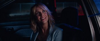 Movie still from “Bridesmaids” (2011), directed by Paul Feig – A woman sitting in a car at night smiling; Close Up shot, Over the shoulder angle