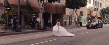 Movie still from “Bridesmaids” (2011), directed by Paul Feig – A woman in a wedding dress walking down the street; Wide shot, Over the shoulder angle