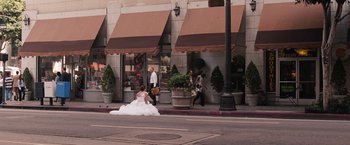 Movie still from “Bridesmaids” (2011), directed by Paul Feig – A woman in a wedding dress sitting on the side of the street; Wide shot, High angle