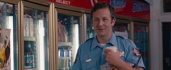 Movie still from “Bridesmaids” (2011), directed by Paul Feig – A man in a uniform holding a cup of coffee; Close Up shot, Over the shoulder angle