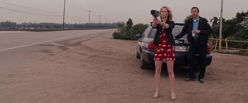 Movie still from “Bridesmaids” (2011), directed by Paul Feig – A woman taking a picture of herself in front of a parked car; Medium shot, Low angle
