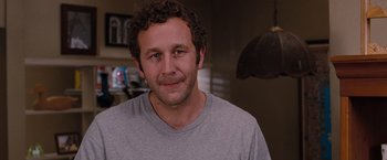 Movie still from “Bridesmaids” (2011), directed by Paul Feig – A person with curly hair wearing a gray shirt; Close Up shot, Over the shoulder angle