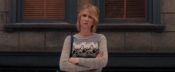 Movie still from “Bridesmaids” (2011), directed by Paul Feig – A woman standing with her arms crossed in front of a building; Medium shot, Over the shoulder angle