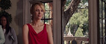 Movie still from “Bridesmaids” (2011), directed by Paul Feig – A woman in a red dress standing in front of a window; Medium shot, Over the shoulder angle