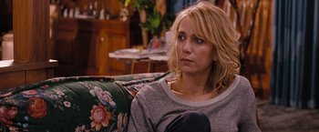 Movie still from “Bridesmaids” (2011), directed by Paul Feig – A woman sitting on top of a couch in a living room; Close Up shot, Over the shoulder angle