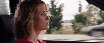 Movie still from “Bridesmaids” (2011), directed by Paul Feig – A woman sitting in the passenger seat of a car looking out the window; Close Up shot, Over the shoulder angle
