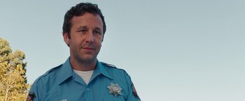 Movie still from “Bridesmaids” (2011), directed by Paul Feig – A man in a police uniform is looking at the camera; Close Up shot, Low angle
