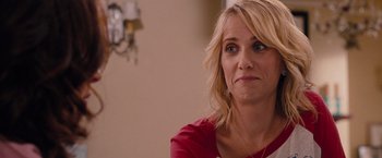 Movie still from “Bridesmaids” (2011), directed by Paul Feig – A woman sitting in front of a wall with her eyes wide open; Close Up shot, Over the shoulder angle