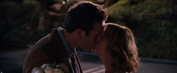 Movie still from “Bridesmaids” (2011), directed by Paul Feig – A man and a woman kissing on the side of a road; Close Up shot, Over the shoulder angle