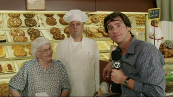 Movie still from “Bruce Almighty” (2003), directed by Tom Shadyac – Two men and an old woman in a bakery; Medium shot, Over the shoulder angle