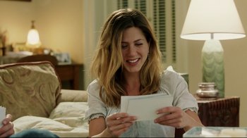 Movie still from “Bruce Almighty” (2003), directed by Tom Shadyac – A beautiful young lady sitting in front of an open envelope; Medium shot, Over the shoulder angle