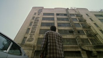 Movie still from “Bruce Almighty” (2003), directed by Tom Shadyac – A man standing in front of a tall building; Extreme Wide shot, Low angle