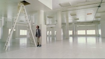 Movie still from “Bruce Almighty” (2003), directed by Tom Shadyac – A man standing next to a ladder in an empty room; Extreme Wide shot, Low angle