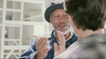 Movie still from “Bruce Almighty” (2003), directed by Tom Shadyac – An older man and a younger man clapping hands; Medium shot, Over the shoulder angle