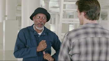 Movie still from “Bruce Almighty” (2003), directed by Tom Shadyac – A man with a hat on talking to another man; Medium shot, Over the shoulder angle