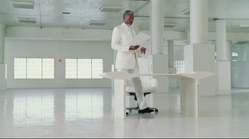Movie still from “Bruce Almighty” (2003), directed by Tom Shadyac – A man in a white suit standing in an empty room; Wide shot, Low angle