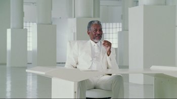 Movie still from “Bruce Almighty” (2003), directed by Tom Shadyac – An older man in a white suit sitting in a chair; Wide shot, Over the shoulder angle
