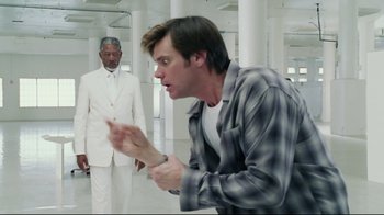 Movie still from “Bruce Almighty” (2003), directed by Tom Shadyac – A man in a white suit and a man in a white suit and a man in a white suit and a man in a white suit; Medium shot, Over the shoulder angle