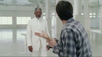 Movie still from “Bruce Almighty” (2003), directed by Tom Shadyac – A man in a white suit is talking to another man in a white suit; Medium shot, Over the shoulder angle