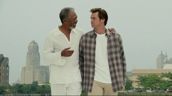 Movie still from “Bruce Almighty” (2003), directed by Tom Shadyac – Two men standing next to each other in front of a city skyline; Medium shot, Low angle