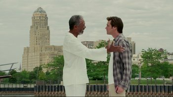 Movie still from “Bruce Almighty” (2003), directed by Tom Shadyac – Two men standing next to each other in front of a city skyline; Medium shot, Over the shoulder angle