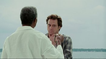 Movie still from “Bruce Almighty” (2003), directed by Tom Shadyac – A man putting a necklace on another man's neck; Close Up shot, Over the shoulder angle