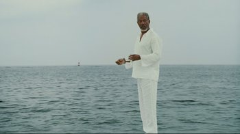 Movie still from “Bruce Almighty” (2003), directed by Tom Shadyac – An older man standing in the water holding a fishing rod; Wide shot, Low angle