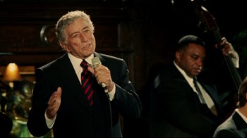 Movie still from “Bruce Almighty” (2003), directed by Tom Shadyac – A man holding a microphone while standing next to another man; Medium shot, Over the shoulder angle