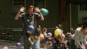 Movie still from “Bruce Almighty” (2003), directed by Tom Shadyac – A man juggling a bunch of balloons in front of a group of children; Medium shot, Low angle