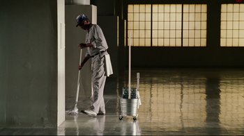 Movie still from “Bruce Almighty” (2003), directed by Tom Shadyac – A man is cleaning the floor with a mop; Wide shot, Low angle