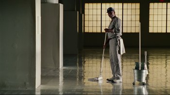 Movie still from “Bruce Almighty” (2003), directed by Tom Shadyac – A man is mopping the floor of a building; Wide shot, Low angle