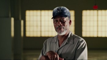 Movie still from “Bruce Almighty” (2003), directed by Tom Shadyac – An older man wearing a baseball cap and a shirt; Close Up shot, Low angle
