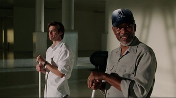 Movie still from “Bruce Almighty” (2003), directed by Tom Shadyac – Two men standing next to each other in a room; Medium shot, Over the shoulder angle