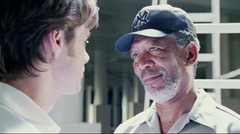 Movie still from “Bruce Almighty” (2003), directed by Tom Shadyac – A man wearing a yankees hat talking to a boy; Close Up shot, Over the shoulder angle