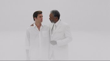 Movie still from “Bruce Almighty” (2003), directed by Tom Shadyac – A man and a man in a white suit standing next to each other; Medium shot, Low angle