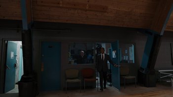Movie still from “Better Call Saul” (2015), created by Vince Gilligan – A man in a suit standing in front of an open door; Wide shot, Over the shoulder angle
