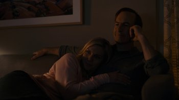 Movie still from “Better Call Saul” (2015), created by Vince Gilligan – A man and a woman sitting on a couch in the dark; Medium shot, Low angle
