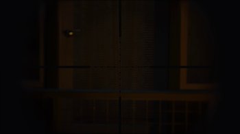 Movie still from “Better Call Saul” (2015), created by Vince Gilligan – A blurry image of a rifle scope in a dark room; Wide shot, High angle