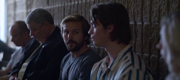 Movie still from “Chambers” (2019), created by Leah Rachel – A man with a goatee and a beard is looking into the distance; Close Up shot, Over the shoulder angle